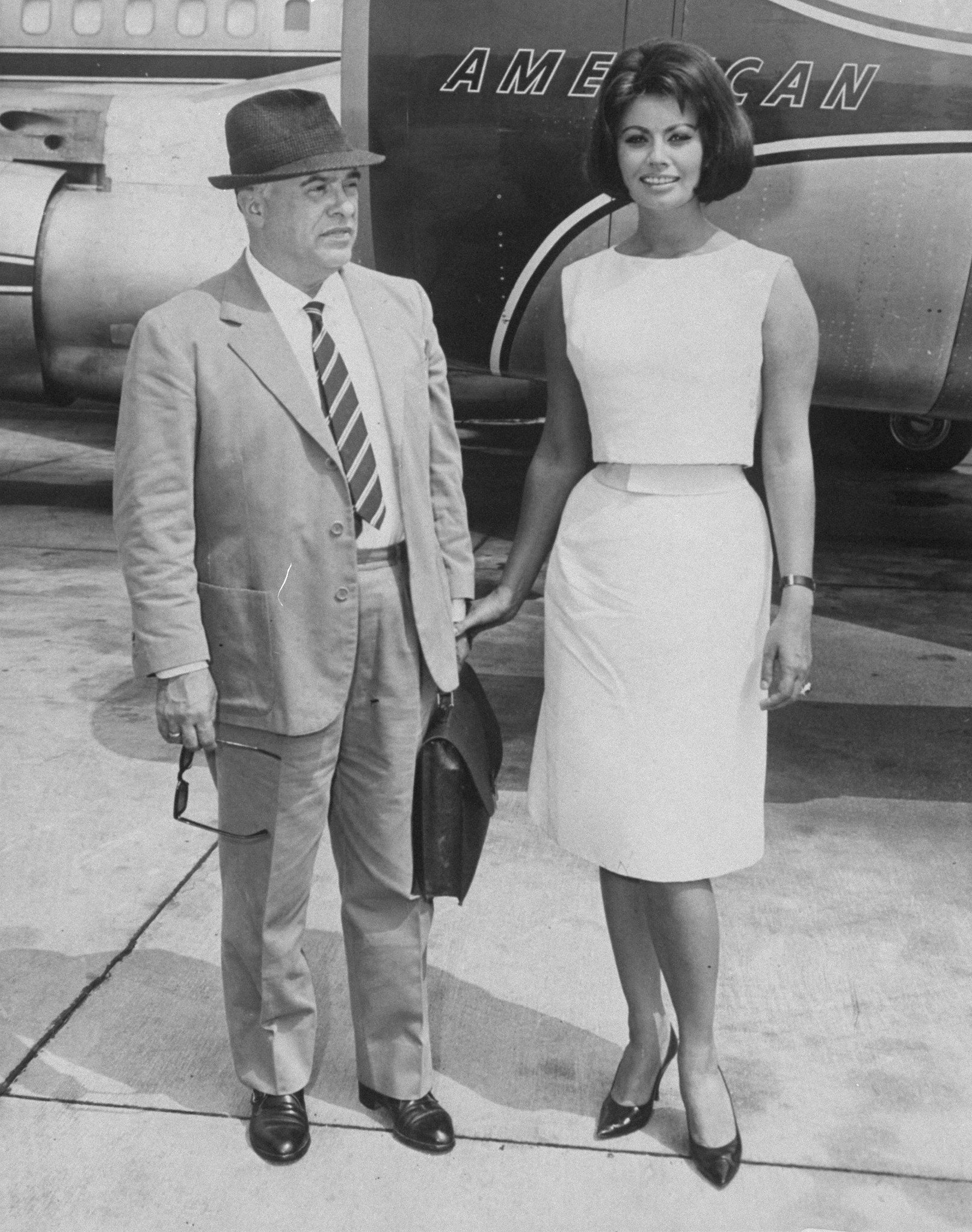 Sophia Loren with her husband, Carlo Ponti, before boarding jet plane at Idlewild Airport for the West Coast. | Source: Getty Images